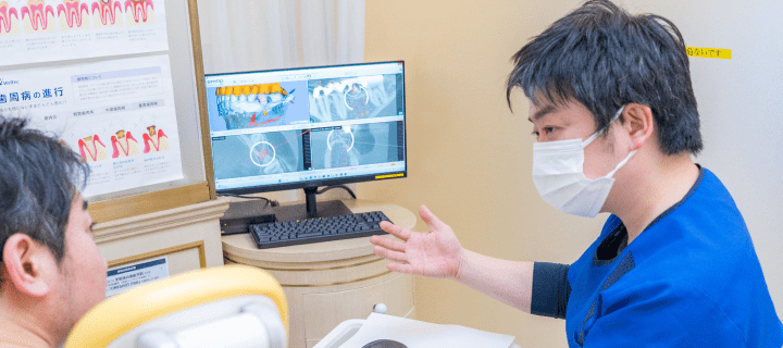口腔内の状態と治療方法の説明をしている画像
