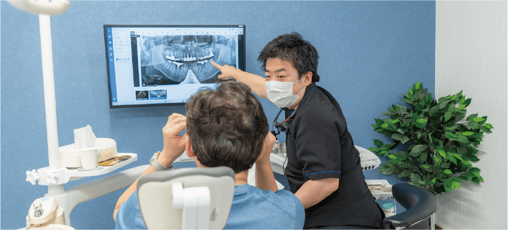 口腔内の状態と治療方法の説明をしている画像